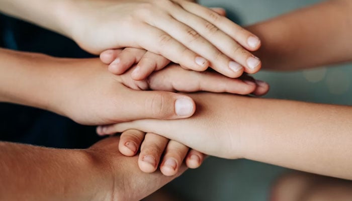 This representational image shows hands to represent the concept of unity and teamwork. — Unsplash/File