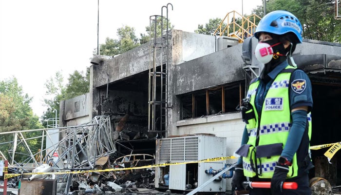 A police officer stands in front of a heavily damaged production line for rocket propellant of Hanwha Aerospaces factory after an explosion, in Daejeon, South Korea, June 1, 2026.—Reuters