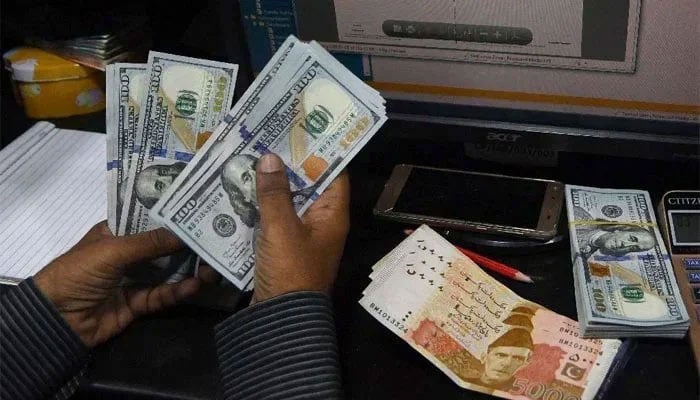 A trader can be seen counting the US currency. —AFP/File