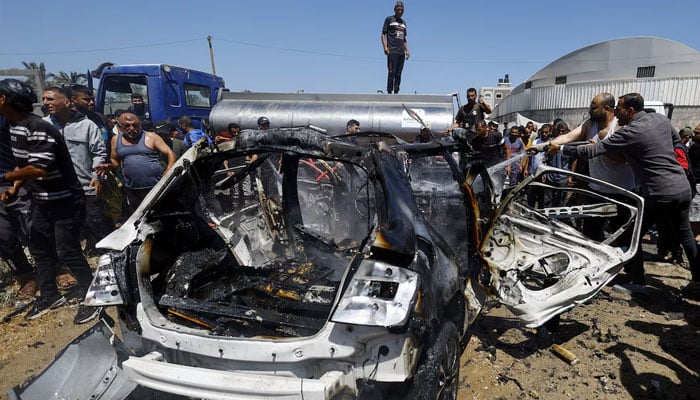 Palestinians gather at the site of an Israeli strike on a vehicle, in Deir al-Balah, in the central Gaza Strip June 2, 2026.—Reuters
