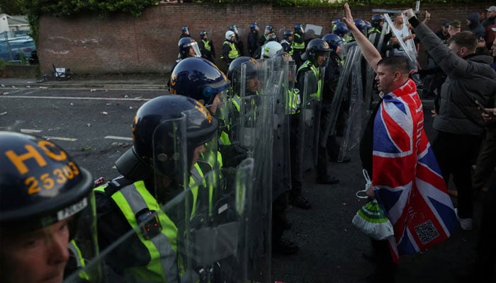 Protesters stand facing police officers during a demonstration following the conviction of Vikrum Digwa for the murder of student Henry Nowak, in Southampton, Britain, June 2, 2026.—Reuters