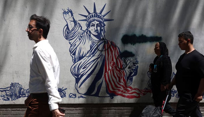 People walk past an anti-U.S. mural on a street in Tehran, Iran, June 1, 2026.—Reuters