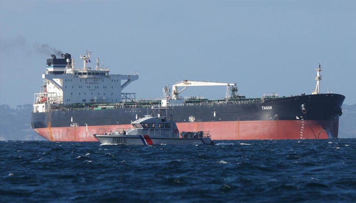 A French Navy vessel sails by the Russian oil tanker Tagor, suspected of flying a false Cameroonian flag and boarded by the French Navy on May 31, 2026. —AFP
