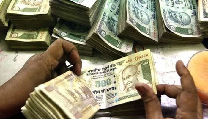 A representational image of a person counting through Indian money. — AFP/File