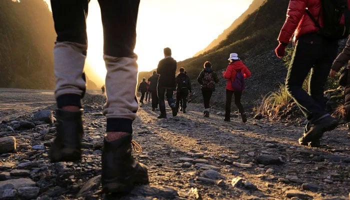 Representational image of people walking on a mountainous road. — Unsplash/File