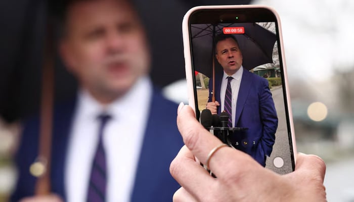 A reporter films with her phone as US Federal Housing Finance Agency Director Bill Pulte speaks with reporters at the White House in Washington, DC, US, January 9, 2026. — Reuters