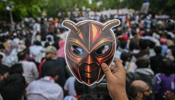 A Cockroach Janta Party (CJP) supporter holds a cockroach mask during a protest over alleged irregularities in the countrys major examinations on June 6, 2026.—Reuters