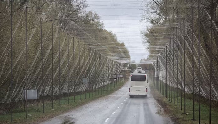 A bus drives on a road covered with an anti-drone net near the Chornobyl Nuclear Power Plant, amid Russias attack on Ukraine, in Kyiv region, Ukraine, April 26, 2026.—Reuters