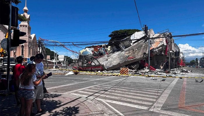 People stand near a collapsed building after a magnitude 7.8 quake in General Santos, Philippines, June 8, 2026. —Reuters