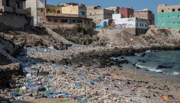 A polluted coastal settlement where plastic waste and poor sanitation threaten both marine life and public health.—AFP/File