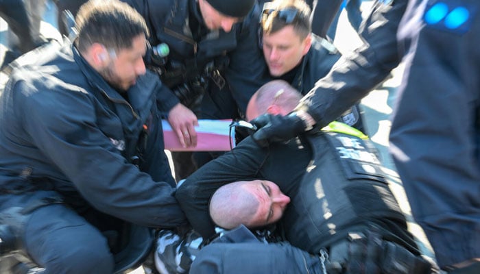Police detain a protester during a demonstration by far-right supporters in Berlin on March 22, 2025.—AFP