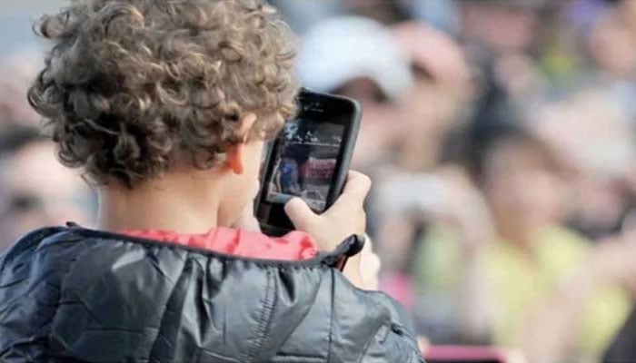 This photo taken on April 20, 2013 shows a child using a smartphone at Caulfield Racetrack in Melbourne. — AFP/File