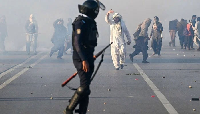 A PTI supporter gestures as police fire tear gas shells to disperse the crowd in Islamabad on November 26. — AFP