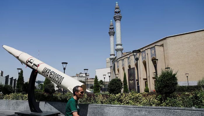 A man walks next to a symbolic mock-up of an Iranian missile, on a street in Tehran, Iran, June 11, 2026.—Reuters