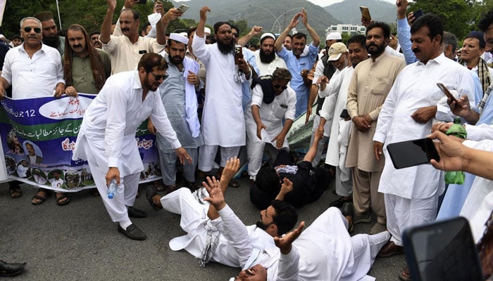 A demonstrator collapses as government employees protest against inflation, demanding better wages, outside the Parliament House before the start of the budget session in Islamabad on June 12, 2026. — INP