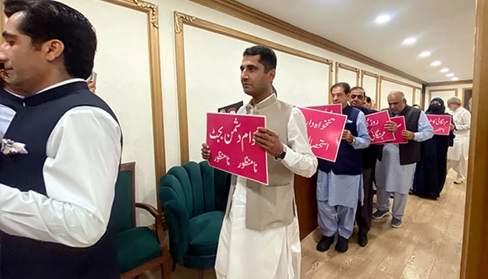 Opposition members of the National Assembly hold placards ahead of entering the assembly before the budget session on June 12, 2026. — NNI