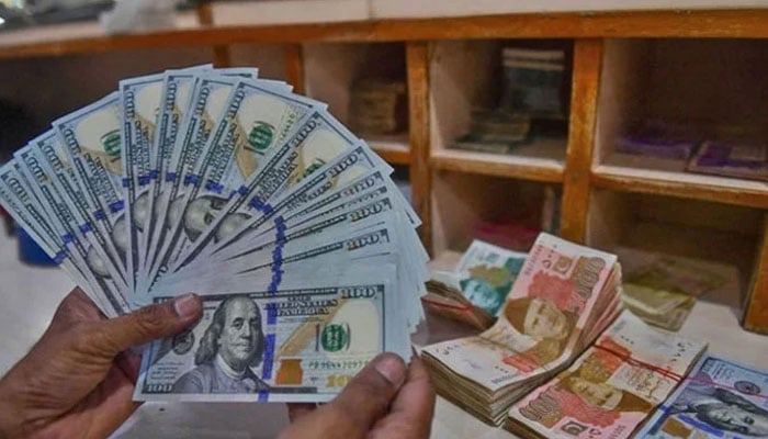 A foreign currency dealer counts US dollars at a shop in Karachi, Pakistan, on May 19, 2022. — AFP/File