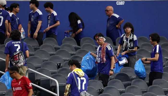 Japan fans clear trash in the stands during the FIFA World Cup 2026 Group F match between the Netherlands and Japan at Dallas Stadium on June 14, 2026, in Arlington, Texas. —AFP