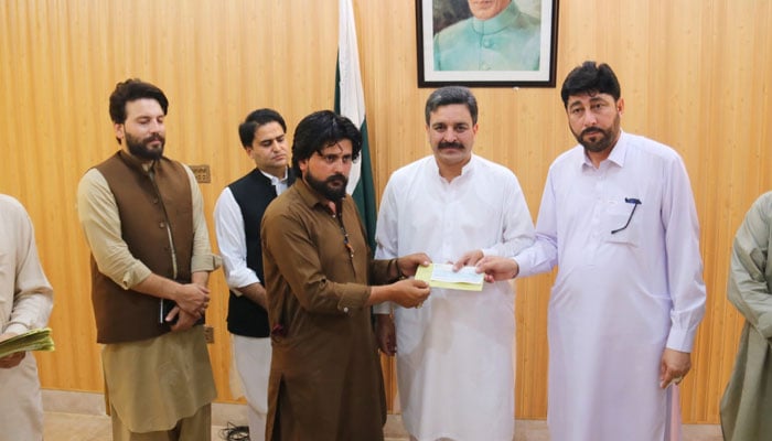 Member of the Khyber Pakhtunkhwa Assembly, Dr Hameedur Rehman, (right) and Deputy Commissioner, Bajaur, Shahid Ali, distribute the cheques among martyred and 40 injured persons during the recent operation in the Mamond tehsil of Bajaur district on June 16, 2026. — Facebook@dcbajaur1