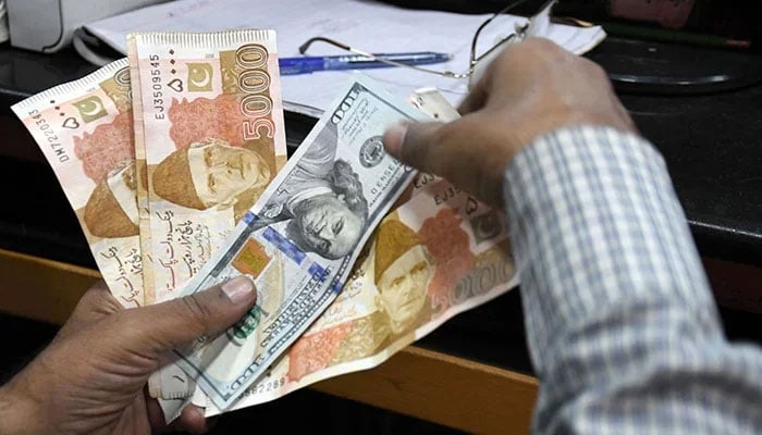 A foreign currency exchanger counts Pakistani rupee notes at a shop in Karachi, on March 2, 2023. — Online