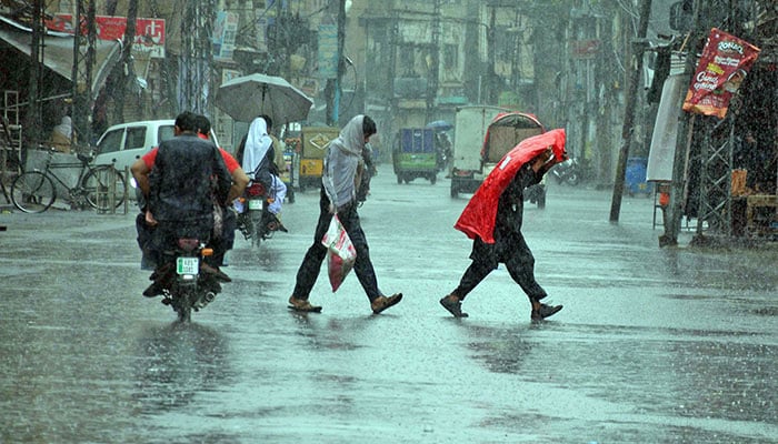 People on their way during heavy monsoon rain. — Online/File