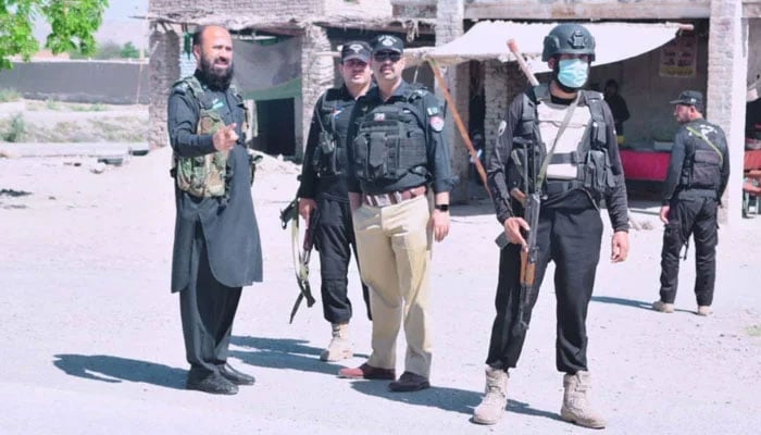 KP police personnel stand guard on the road on May 6, 2024. — Facebook@Bannu Police