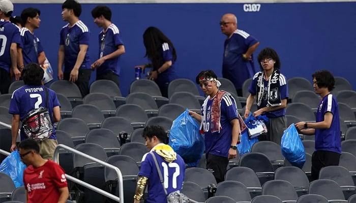 Japan fans clear trash in the stands during the FIFA World Cup 2026 Group F match between Netherlands and Japan at Dallas Stadium on June 14, 2026 in Arlington, Texas. — AFP
