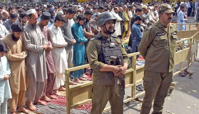 People offer prayers while security personnel stand alert during Nimaz-e-Juma at Masjid-e-Shuhada in Lahore on March 14, 2025. — Online
