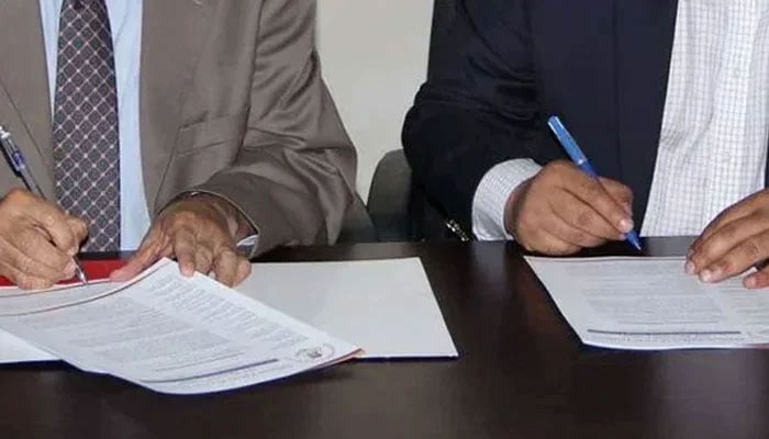This representational image shows officials signing documents. — APPNA website/File
