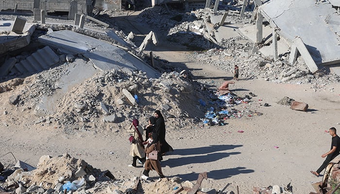 Palestinians walk past residential buildings destroyed during the war in Khan Younis in the southern Gaza Strip, June 18, 2026. — Reuters