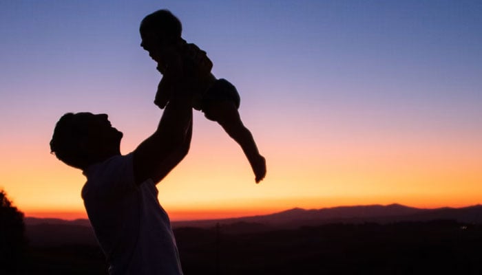This representational image shows the silhouette of a person lifting a child in the sky. — Unsplash/File