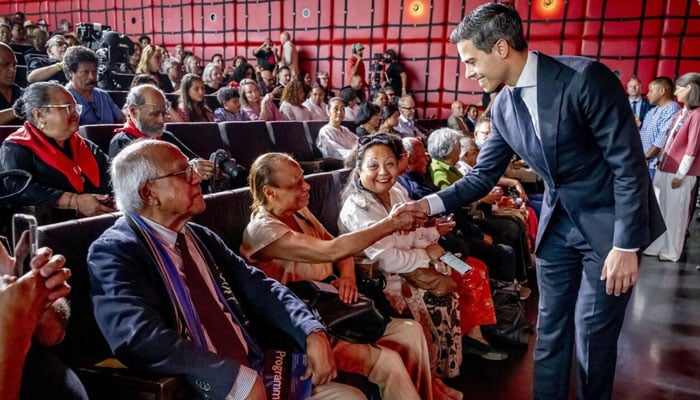 Dutch Prime Minister Rob Jetten shakes hand with a lady of the Moluccan community. —AFP