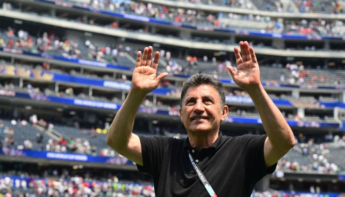 Irans head coach Amir Ghalenoei waves to the fans. — AFP