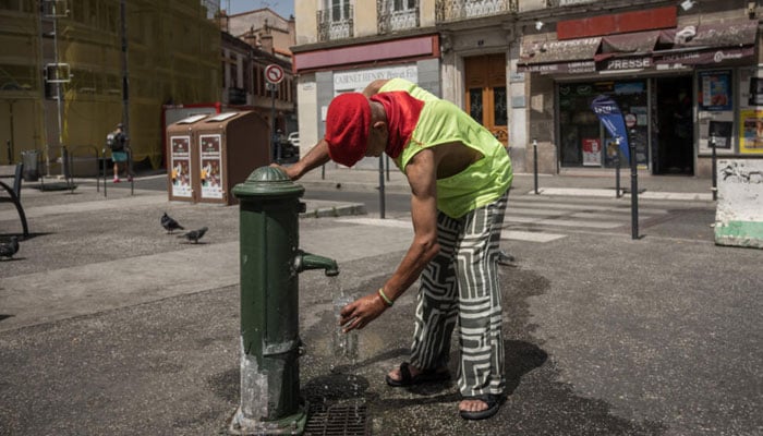 A person filling a water bottle from a water pump in  France. —AFP/File