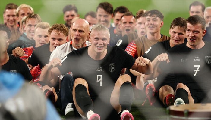 Erling Haaland led his Norway teammates in their Viking row celebration after they defeated Senegal to reach the World Cup knockout rounds. —AFP