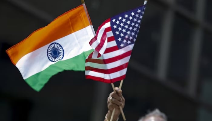 A man holds the flags of India and the U.S. while people take part in the 35th India Day Parade in New York August 16, 2015.— Reuters
