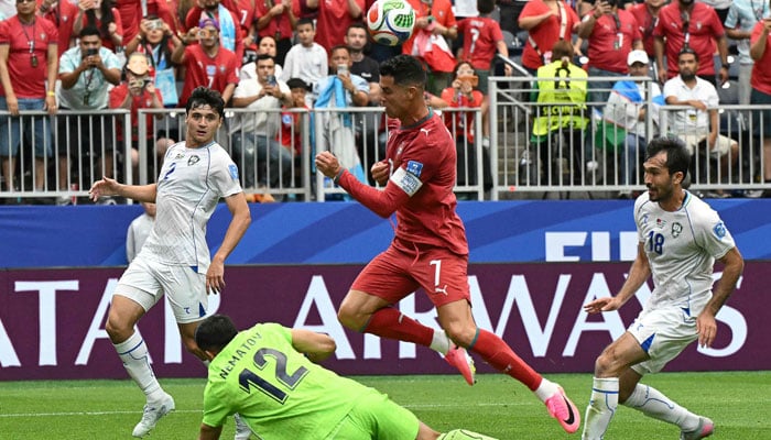 Portugals forward #07 Cristiano Ronaldo (C) fights for the ball with Uzbekistans goalkeeper #12 Abduvohid Nematov (down) during the 2026 World Cup Group K football match between Portugal and Uzbekistan at the Houston Stadium in Houston on June 23, 2026. — AFP