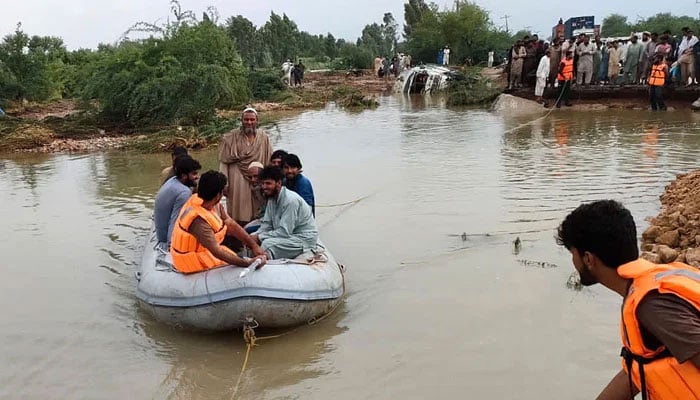 Rescue workers are shifting flood-affected people at Swat Khwazakhela.— INP/File