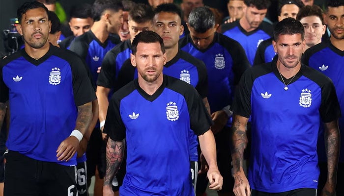 Argentinas Lionel Messi leads his team out for the warm up before the match. —Reuters