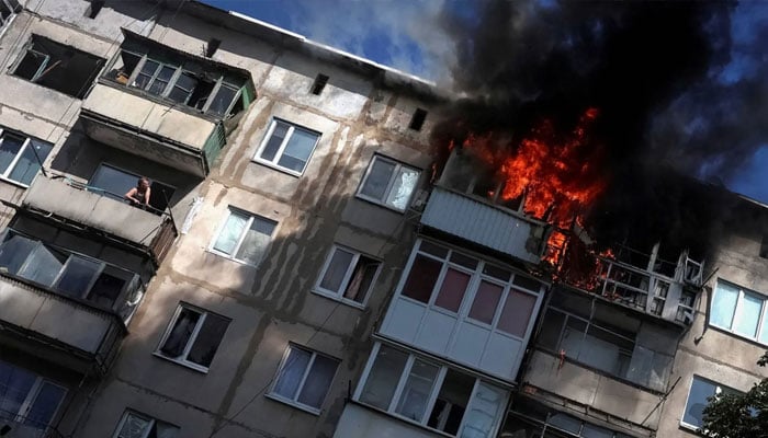 A resident watches from his balcony as another flat burns after being hit by a Russian drone, amid Russias attack on Ukraine, in the frontline town of Druzhkivka, in Donetsk region, Ukraine, June 22, 2026.—Reuters