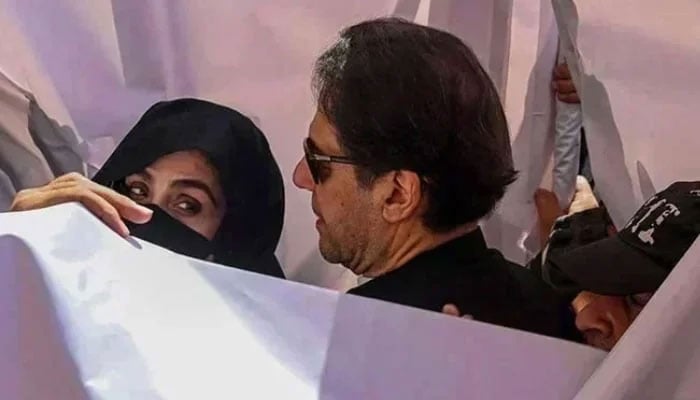 PTI founder Imran Khan with his wife Bushra Bibi arrive to appear in a high court in Lahore on May 15, 2023. — AFP