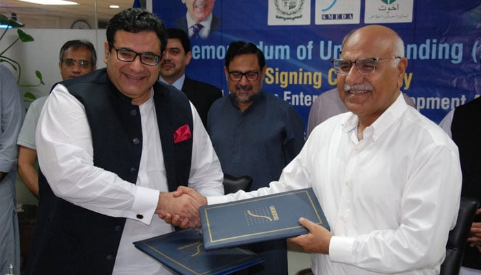 CEO SMEDA Socrat Aman Rana and Chairman Akhuwat Foundation Dr Amjad Saqib exchanging the MoU files at SMEDA’s head office in Lahore. —Facebook@smedapakistan