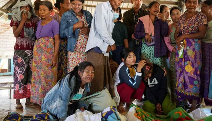 Mourners grieve as bodies are laid out at a cemetery after a Myanmar military strike at a hospital killed more than 30 people in western Rakhine state on December 11, 2025. —AFP/File