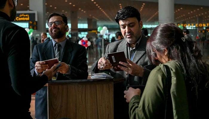 Immigration officers check the documents of passengers before boarding at the Islamabad International Airport on January 10, 2025. — AFP