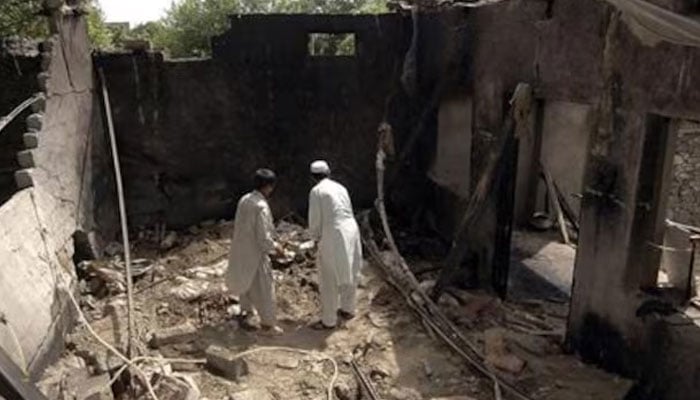 Residents stand inside a damaged house after a missile attack in Damadola village of the Bajaur tribal region in Pakistan May 15, 2008.—Reuters