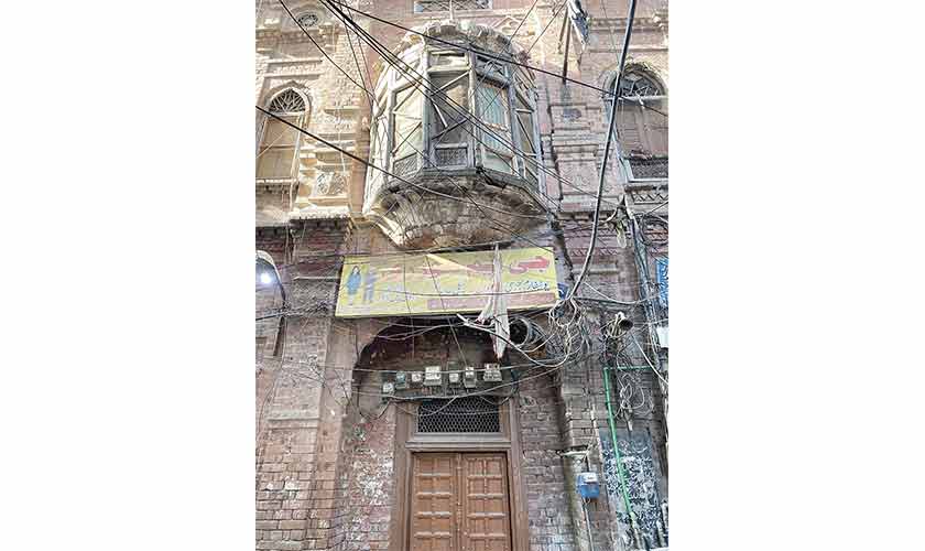 Electric wires, panaflexes and old Jharoka in a street of old Lahore.