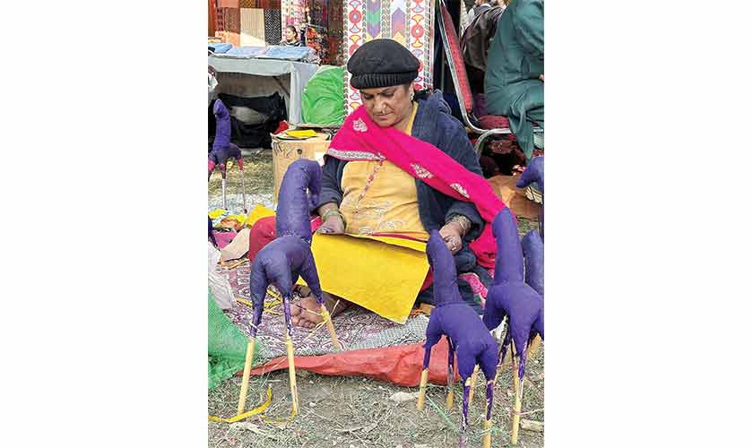 A lady making colorful traditional horses from paper.