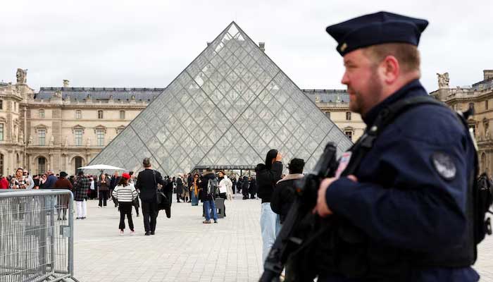A French CRS riot police officer patrols near the glass Pyramid of the Louvre Museum, after French police arrested suspects in the Louvre heist case, in Paris, France on October 27, 2025. — Reuters
