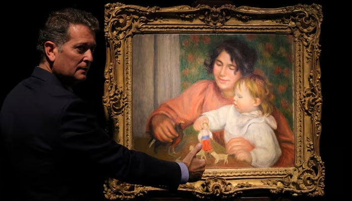 Art consultant Pascal Perrin stands next to the painting (Child with Toys - Gabrielle and the Artists Son, Jean), before 1910, by artist Pierre-Auguste Renoir (1841-1919) on display before its auction at Drouot auction house in Paris, France, October 14, 2025. — Reuters