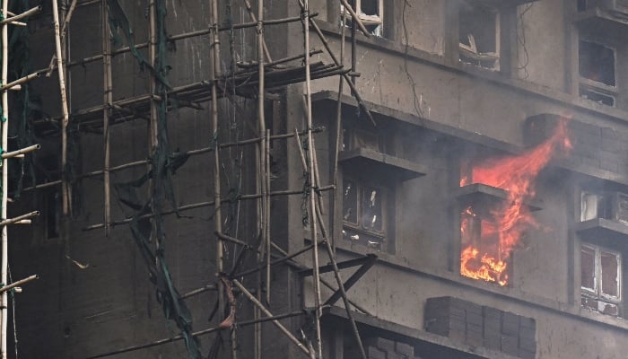 An apartment still burns as a major fire swept through several apartment blocks at the Wang Fuk Court residential estate in Hong Kongs Tai Po district on November 27, 2025. — AFP